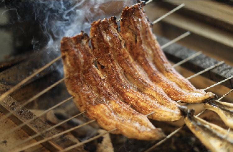 うなぎを串にさして炭火で焼いている様子